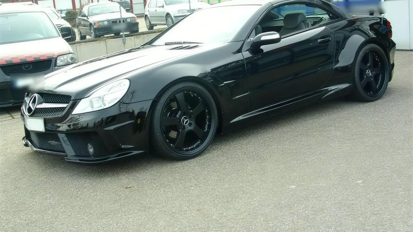 Frisch lackierter schwarzer Mercedes SL vor der Werkstatt