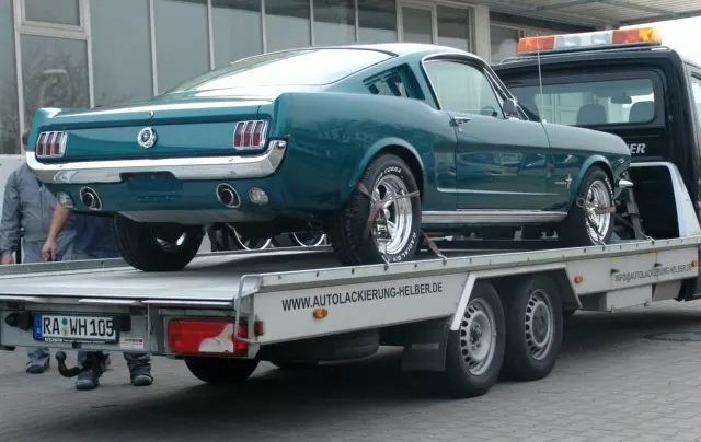 Ford Mustang Fastback in dunklem Türkismetallic auf dem Transporter der Autolackierung Helber