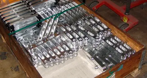 Blank bearbeitete Aluminium-Serienteile in einer Transportkiste, bereit zur Auslieferung