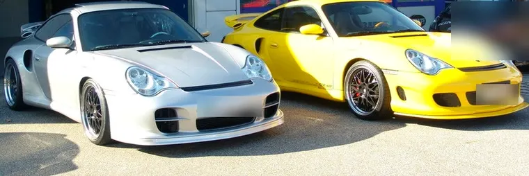 Zwei tiefergelegte Porsche 911 in Silber und Gelb nebeneinander nach der Lackierung
